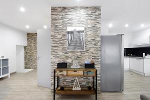 a living room with a brick wall and a table at Guesthouse dos Limites in Espinho