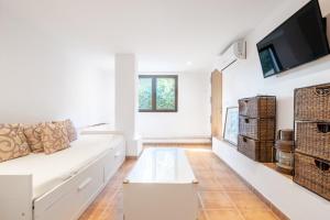 a living room with a white couch and a flat screen tv at Villa Sant Vicente in Cala de Sant Vicenc