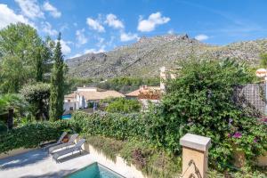 a resort with a pool with a mountain in the background at Villa Sant Vicente in Cala de Sant Vicenc