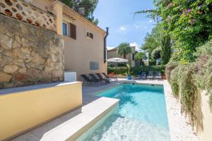 a swimming pool in front of a house at Villa Sant Vicente in Cala de Sant Vicenc