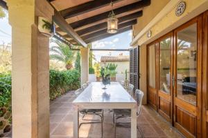 a patio with a white table and chairs on a porch at Villa Sant Vicente in Cala de Sant Vicenc