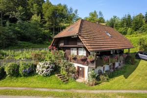 a small house with flowers in the yard at Schwarzwald Buchenhof in Zell am Harmersbach