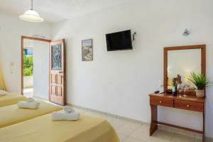 a hotel room with two beds and a mirror at Studios Asterias 4 in Astypalaia