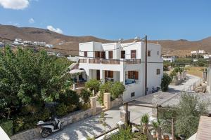 a white house with a scooter parked in front of it at Studios Asterias 4 in Astypalaia
