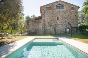 a swimming pool in front of a stone house at L'Altell in Montagut