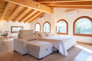 a bedroom with a bed and a chair and windows at L'Altell in Montagut +21 photos