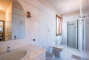 a white bathroom with a sink and a toilet at Villa Vanna - Certaldo in Vico dʼElsa