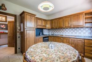 a kitchen with a table and wooden cabinets at Villa Vanna - Certaldo in Vico dʼElsa +13 photos