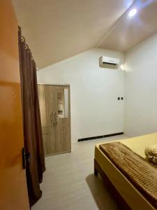a bedroom with a bed and a bathroom with a shower at Sekar Homestay in Bantul +10 photos