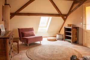 a living room with a chair and a rug at Fewo Hohe Liebe in Rathmannsdorf