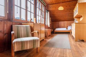 ein Zimmer mit einem Stuhl und einem Schreibtisch und Fenstern in der Unterkunft Haus Botter in Klobenstein