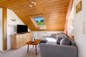 a living room with a couch and a tv at Schwarzwald Buchenhof in Zell am Harmersbach