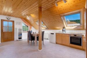 a kitchen with a table and a wooden ceiling at Schwarzwald Buchenhof in Zell am Harmersbach