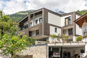 an image of a house with mountains in the background at Aktiv Lodge Meran - Terrace Large in San Martino