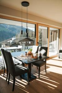 a dining room with a table and chairs and a large window at Aktiv Lodge Meran - Terrace Large in San Martino