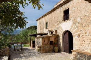 an old stone building with a doorway and a table at Plana Morro in Pollença