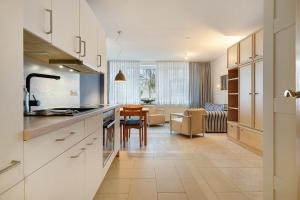 a kitchen with white cabinets and a dining room at Haus Margarete Christel Winkelmann in Cuxhaven