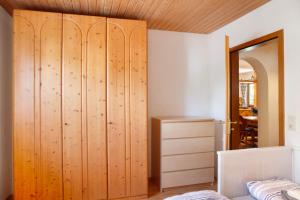 a bedroom with a large wooden closet and a table at Auszeit Brunner in Bad Tölz +19 photos