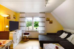 a living room with a couch and a tv at Ferienhaus Gerda Wohnung 1 in Westochtersum +18 photos