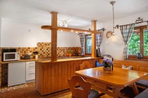 a kitchen with a wooden table and a dining room at Auszeit Brunner in Bad Tölz