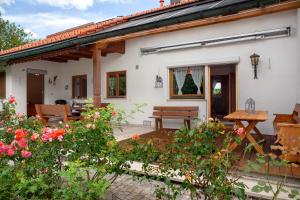 a white house with a bench and flowers at Auszeit Brunner in Bad Tölz