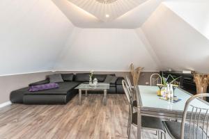 a living room with a black couch and a table at Uhse Wohlfühloase in Heide +26 photos