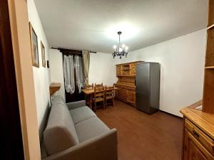 a living room with a couch and a kitchen at Appartamento Bardonecchia in Bardonecchia