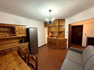 a kitchen with a couch and a refrigerator at Appartamento Bardonecchia in Bardonecchia +2 photos
