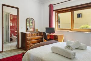 a bedroom with a bed and a desk with a computer at Vermarl - Viana do Castelo in Linhares de Cima