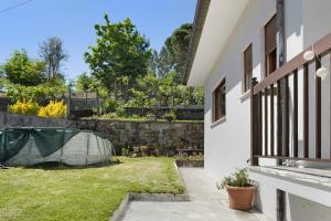 a backyard with a stone wall and a yard with a fence at Vermarl - Viana do Castelo in Linhares de Cima