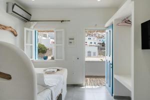 a white room with a bed and a window at Politimis Studio N2 in Amorgos