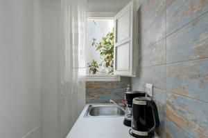 a kitchen with a sink and a window at Politimis Studio N2 in Amorgos