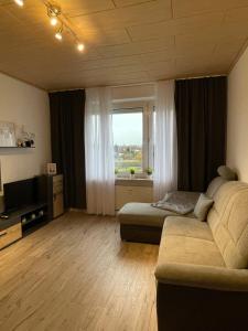 a living room with a couch and a window at Ruhige Ferienwohnung Zeithain in Zeithain