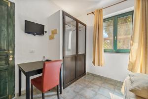 a room with a desk and a red chair at Sa Funtana in Gonnesa