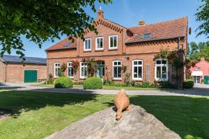 a cat statue sitting on a rock in front of a house at Ferienwohnung Bauernhof Rohde in Gremersdorf