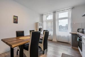 a kitchen and dining room with a wooden table and chairs at Ferienwohnung Am Theaterplatz in Gera