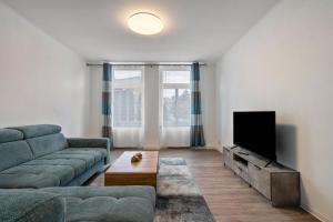 a living room with a couch and a flat screen tv at Ferienwohnung Am Theaterplatz in Gera