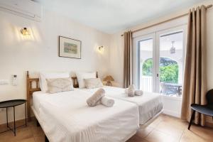 a bedroom with a large white bed and a window at Casa Crystal in Jávea +31 photos