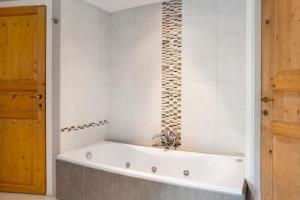 a bath tub in a bathroom next to a door at Casa Rea in Murazzano