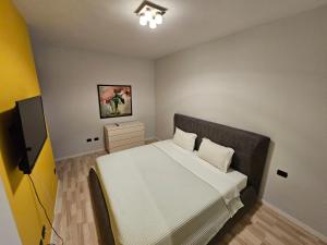 a small bedroom with a bed and a television at central apart in Tirana +7 photos