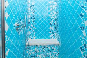 a blue tiled shower with a bench in a bathroom at Mavi Piano Terra in Palau