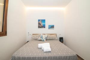 a bedroom with a bed with two towels on it at Mavi Piano Terra in Palau