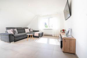 a living room with a couch and a tv at Ferienwohnung Weitblick in Durbach