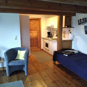 ein Zimmer mit einem Bett, einem Stuhl und einer Küche in der Unterkunft Friesenhaus Anke in Struckum