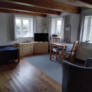ein Wohnzimmer mit einem Tisch und einem Fernseher in der Unterkunft Friesenhaus Anke in Struckum
