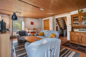 a living room with blue chairs and a wooden ceiling at Dat Haddehuus in Wangerland