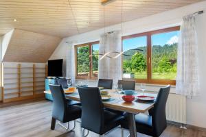 a dining room with a table and chairs and windows at Ferienwohnung Sulzberg, 103qm in Alpirsbach