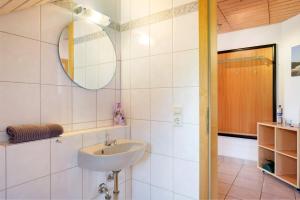 a bathroom with a sink and a mirror at Ferienwohnung Sulzberg, 103qm in Alpirsbach +23 photos