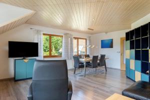 a dining room with a table and chairs and a television at Ferienwohnung Sulzberg, 103qm in Alpirsbach
