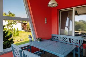 a blue table and chairs on a porch with a window at Ferienhaus Ton Sünhus in Groß Labenz